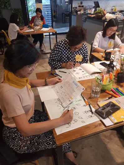 ผู้เข้าอบรมบันทึกแผนพัฒนาตนเองลงในสมุดกิจกรรมระหว่างเวิร์กช็อป
